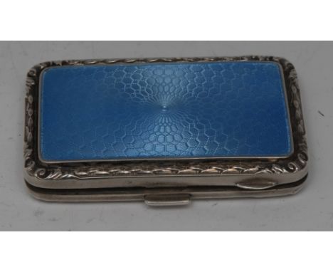 An Art Deco silver and enamel rounded rectangular cigarette case, hinged cover engine turned and decorated in tones of pale b
