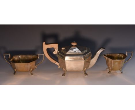 An Art Deco silver three piece canted rectangular tea service, comprising teapot, milk jug and sugar basin, angular scroll ha