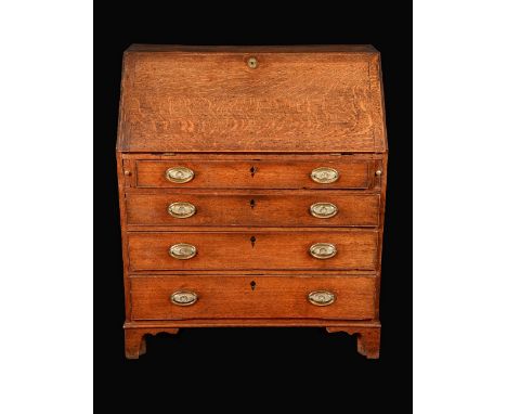 A George III oak bureau, fall front enclosing a cupboard and an arrangement of pigeon holes and small drawers, above four lon