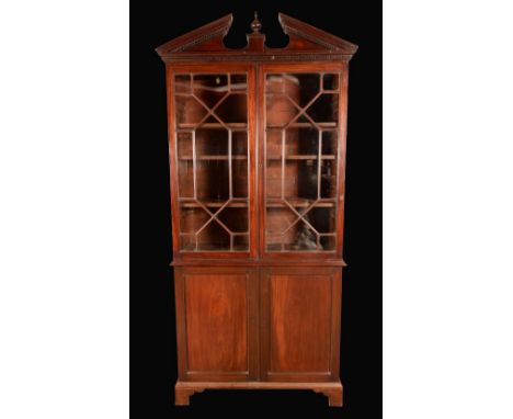 A George III mahogany library bookcase, break arch pediment with dentil cornice above a pair of astragal glazed doors, the ba