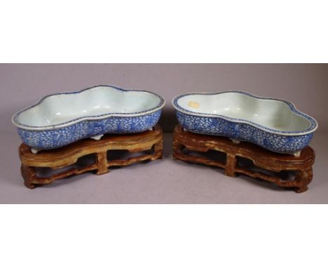 Pair Chinese Qing dynasty ceramic bowls kidney shaped bowls, blue and white decoration, on fitted carved wood stands. Length 