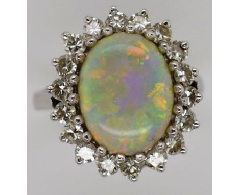 18ct white gold opal and diamond halo ring marked 18ct. approx 12mm x 9.5mm opal cabochon. 18x round brilliant cut diamonds 1