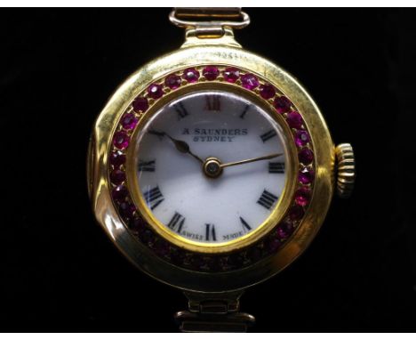 Antique gold and ruby set ladies wrist watch with a manual wind movement. white painted dial showing roman numerals and Saund