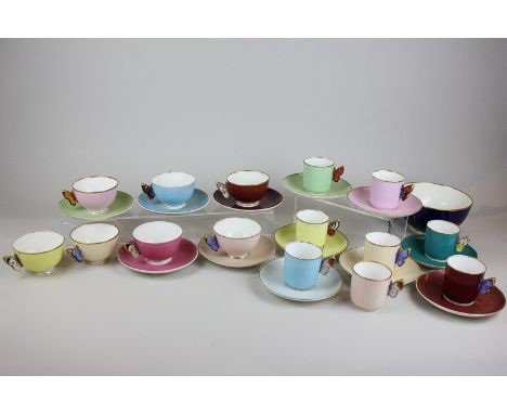 A Harlequin set of eleven Royal Worcester porcelain teacups and saucers in soft block colours with butterfly shaped handles, 