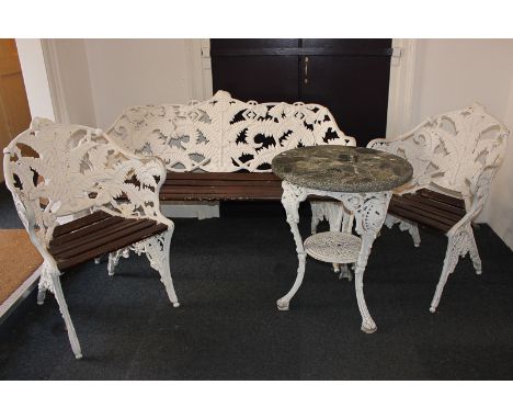 A white painted aluminium garden bench with two matching chairs, both with fern shaped decoration, together with a composite 