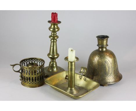 An Indian bell shaped candle holder, two brass chamber sticks and a 19th century brass candlestick