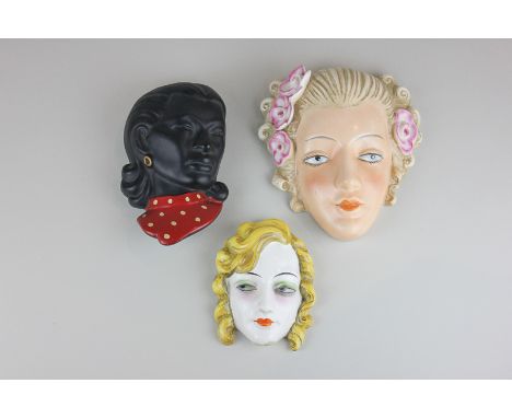 A Goebel porcelain head of a woman with blond hair and pink flowers, crown mark to back, another Goebel head of a lady with g