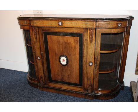 A Victorian walnut credenza decorated with floral ceramic plaques and banded wood, the central panel door enclosing one shelf