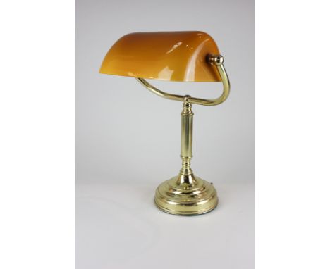 A brass student's desk lamp with yellow glass shade