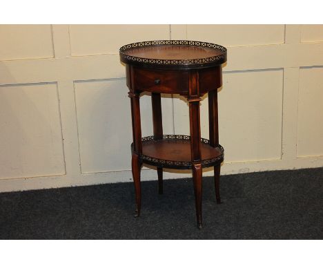 A mahogany oval occasional table with galleried top, leather inset, with one drawer, with stretcher shelf inset with leather 