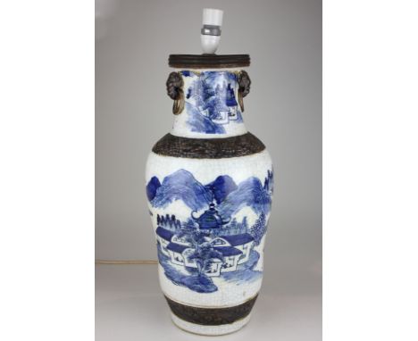 A Chinese blue and white pottery table lamp depicting a landscape, with brown raised pattern bands and fo dog ring lugs (af) 