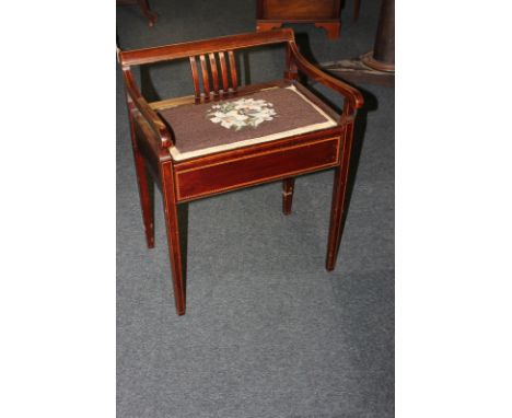 An inlaid mahogany piano stool with low back and arm support, tapestry seat over music storage, on square tapered legs