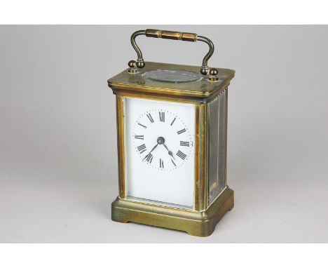 A brass and bevelled glass cased carriage clock, the white enamel rectangular dial with Roman numerals, 14cm high