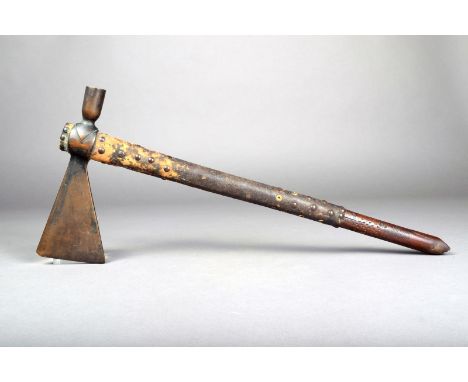A Native American Tomahawk pipe, the wood shaft with incised decoration near the tapering mouth piece, with studded leather b
