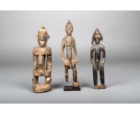 Three Senufo standing figures, Ivory Coast, one on a stand, 22.2cm, 20.8cm, 19.5cm high. (3) Provanance Ex Old French Colonia