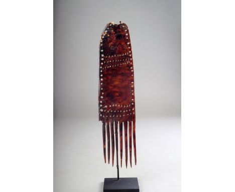 A Collingwood Bay turtle shell comb, Papua New Guinea, with pierced decoration, late 19th century, 27cm long, on a stand. (2)