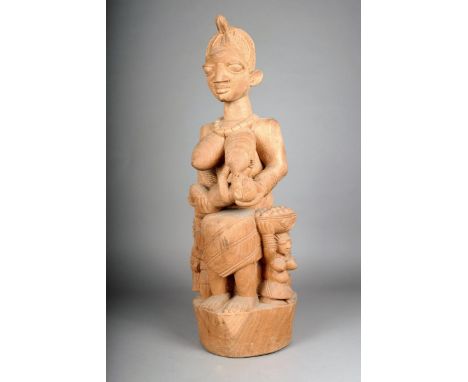 A Yoruba carved maternity figure by Lamidi Olonade Fakeye, with a seated female and a suckling infant, the base with further 