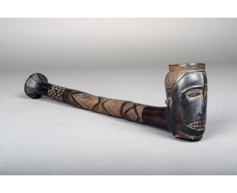 A Kuba pipe, D.R.Congo, carved wood in three sections with a head bowl and geometric decoration, 39.5cm long.