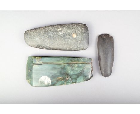 A Maori greenstone axe head, with a faceted end and a gauged line, 18cm long, a Maori basalt axe head with painted inventory 