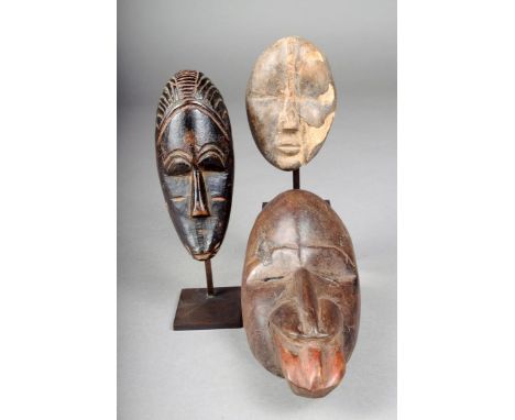 Three Dan portrait masks, Ivory Coast, two on stands, the unmounted mask, 15.5cm high.(3) Provenance French Colonial collecti