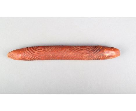 An Aboriginal message stick, Central Desert, carved concentric circles with ochre pigment, 16.5cm long.