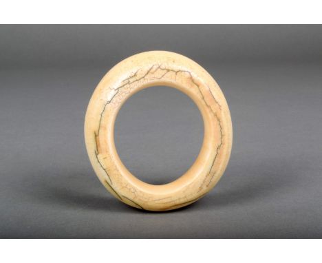 An African ivory bangle, early 20th century, 9.5cm diameter.