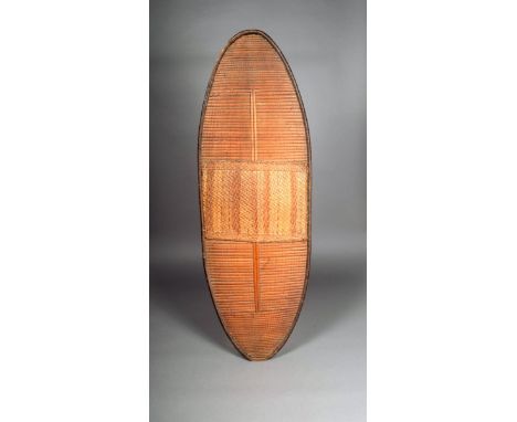 A Mongo shield, D R Congo, of eliptical form, bound reeds with panel front and wood block handle to the reverse, 120.5cm high