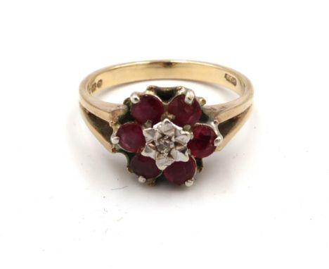 A 9ct gold, ruby and diamond flowerhead ring, the central illusion set diamond surrounded by six rubies, size R, 3.8g.