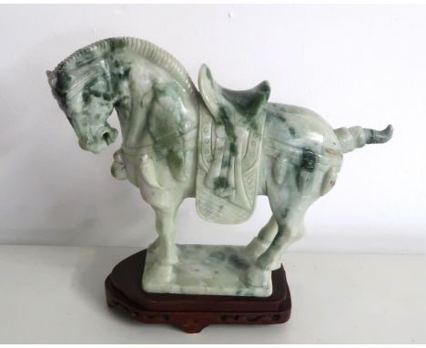 A late 20th century Chinese carved jade horse on wooden stand, 23cm high.