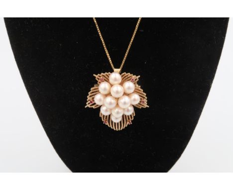 A cultured pearl and ruby foliate brooch/pendant. Stamped 14K. Weight 14.19 grams. Suspended from a gold plated chain