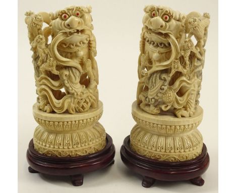 Pair Chinese Carved Ivory Foo Dogs on Hardwood Stands. Inset Coral Eyes. Deep Relief Carving. Unsigned. Typical Light Age Cra