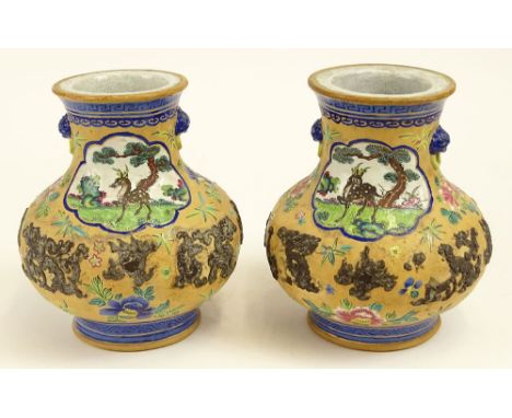 Pair of 20th century Chinese enamel decorated pottery vases with mock ring handles and relief decoration. Unsigned. Losses to