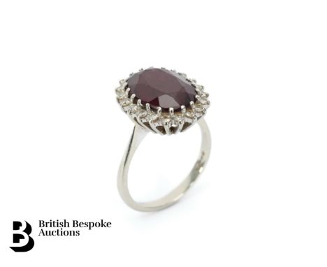 18ct white gold garnet and diamond ring, size M, approx 5.3 gms. The ring set with a central garnet approx 14 x 8mm and 35 pt