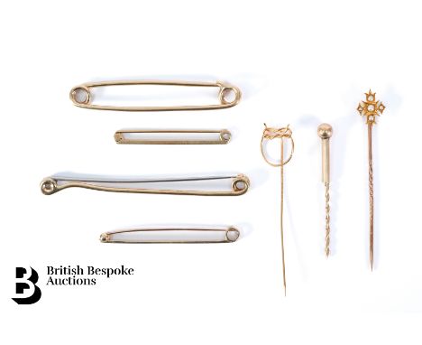 Two 9ct gold stocks pins, another 9ct gold stock pin with (steel pin) together with a 9ct gold toothpick, 9ct gold metal safe