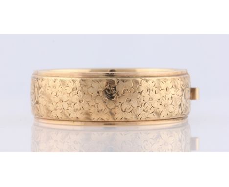 A 9ct yellow gold hinged bangle, half bangle featuring engraved floral design, hallmarked Birmingham 1964.