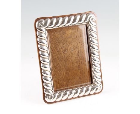 A Victorian silver fronted photograph frame of rope twist scroll design, hallmark rubbed - Chester, 1895, with replaced back,