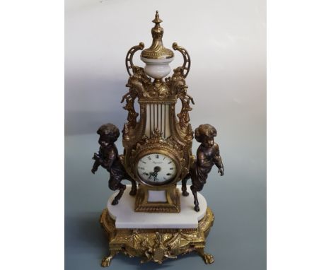 An Italian brass marble ornate mantle clock, bronzed cherub figures either side on claw feet.