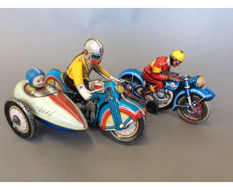 A Dunlop cord wind up tin motorcyclist together with a tin motorcyclist and side car.