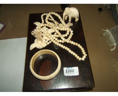 A quantity of Ivory including bangle, bead necklaces and small elephant