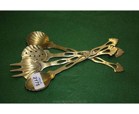 Four decorative brass spoons and a fork.