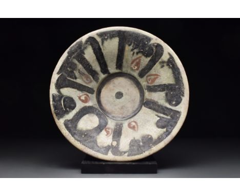 Ca. 10th century AD A terracotta charger in a light brown fabric with a cream interior ornamented with black and brown geomet