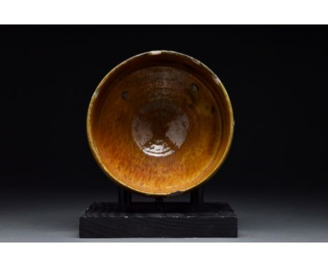 Persia, Ca. 10th-11th century AD A brown glazed pottery bowl of a deep hemispherical-shaped body rising from a ring foot. Fro