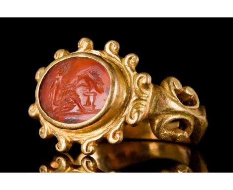 Ca. 300-400 AD An oval intaglio of carnelian engraved with Ganymede seated on a rock and giving a drink from a bowl to the ea