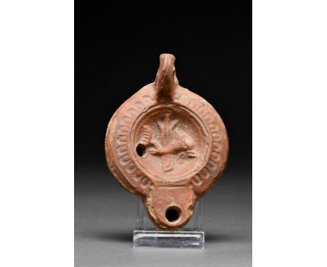 Ca. 1-200 AD A fine terracotta oil lamp with a recessed tondo decorated with a dolphin in front of the rudder. The perimeter 