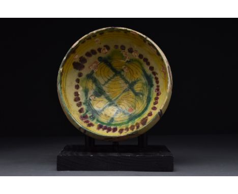 Persia (Nishapur), Ca. 10th century AD A pottery bowl of a conical form on a short unglazed foot. The interior is with cream 
