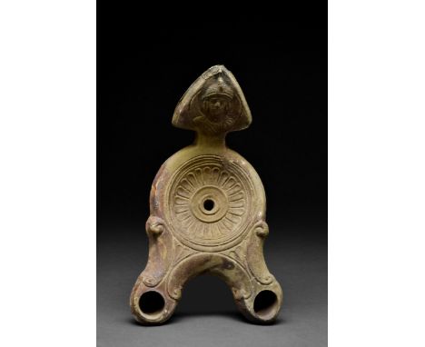 Ca. 1-200 AD A large terracotta oil lamp with a double snout decorated with volutes on the sides, and a handle in the form of