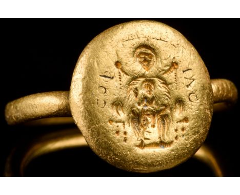 Ca. 600 AD A gold finger ring comprising a round-section hoop and an applied circular bezel bearing an image of seated Mary T