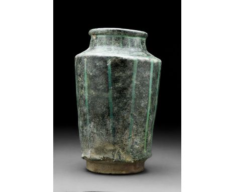 Kashan, Persia, Ca. 13th century AD A classic pottery albarello jar with layers of intense dark green glaze with vertical tur