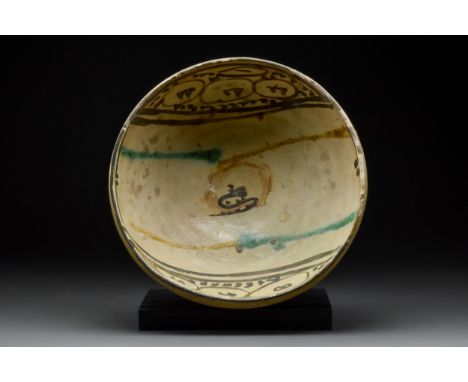 Iraq or Persia, Ca. 8th-10th century AD A ceramic shallow bowl with wide, flaring sides and a low disc foot. The interior is 