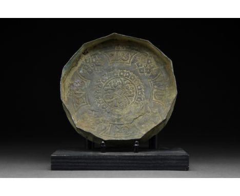 Ca. 14th century AD A copper polygonal plate with a wide, flat base. The plate is covered with engraved decorations of floral